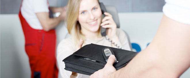 una mujer hablando por el móvil mientras sostiene una cartera