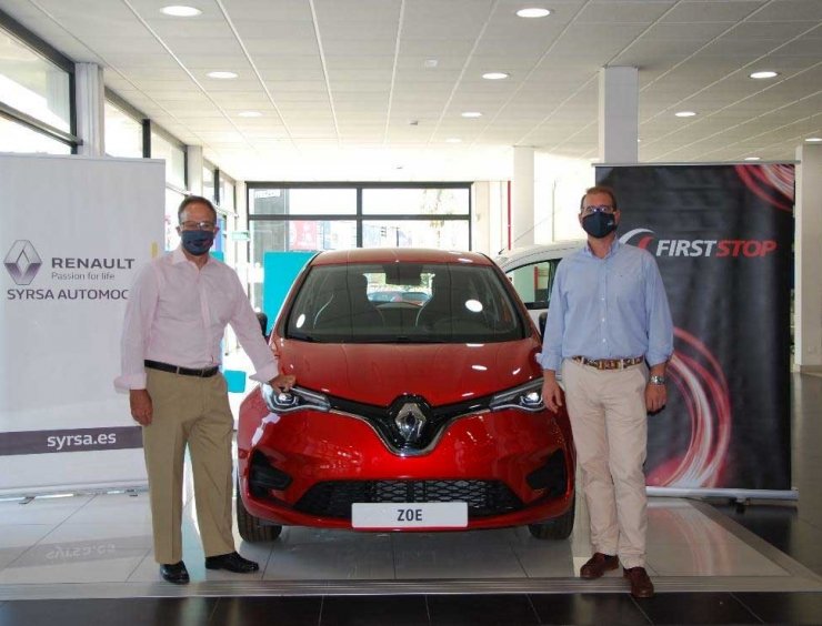 dos hombres junto a un coche rojo