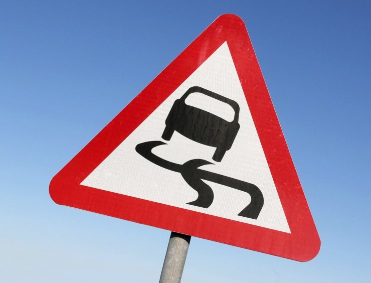 un cartel triangular rojo y blanco con la imagen de un coche