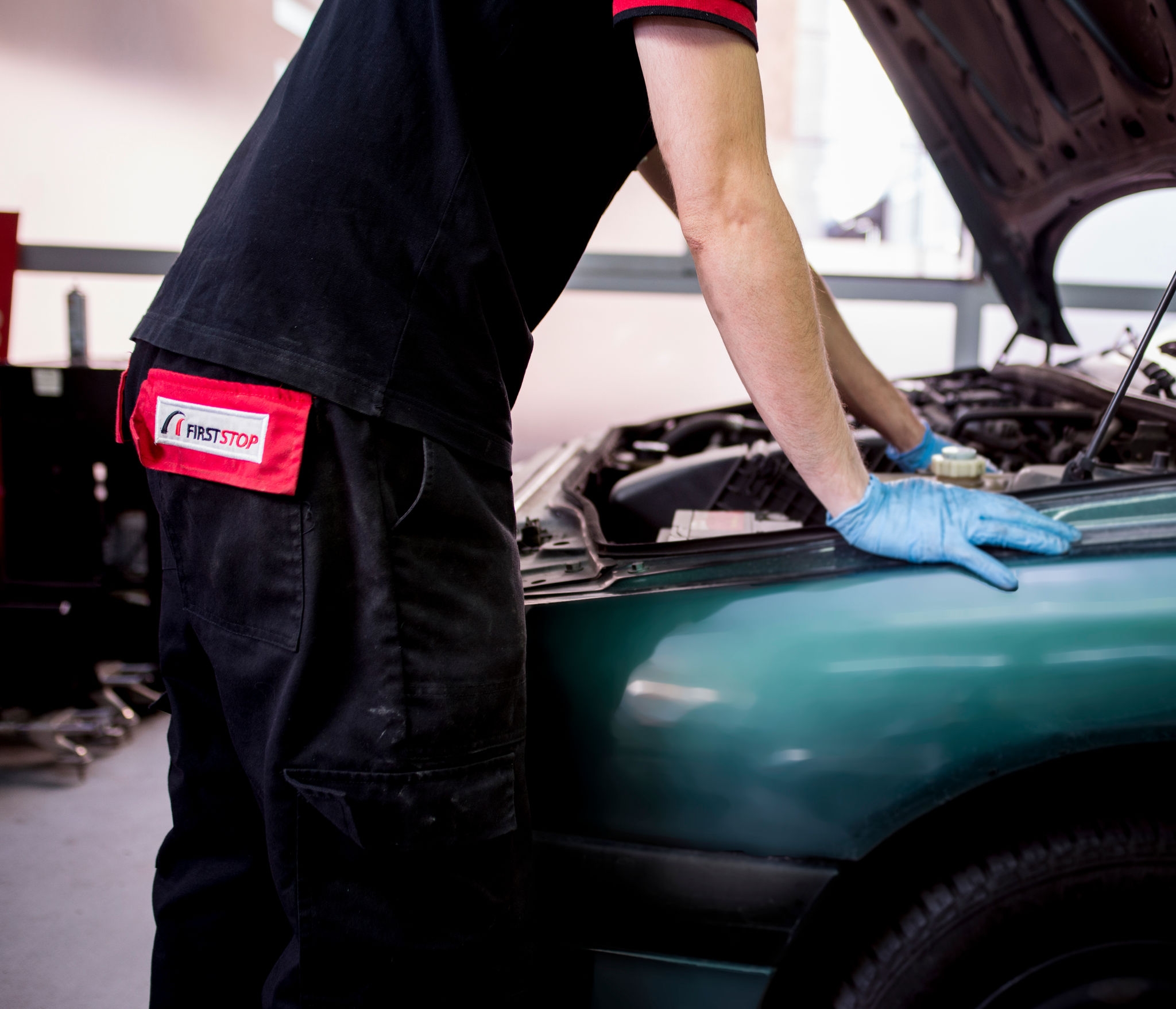 Mecánico revisa el motor con capó abierto 